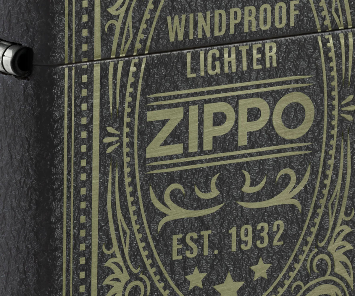 Detailaufnahme des Zippo Antikes Logo mit Schriftzug, Ornamenten und strukturierter Oberfläche