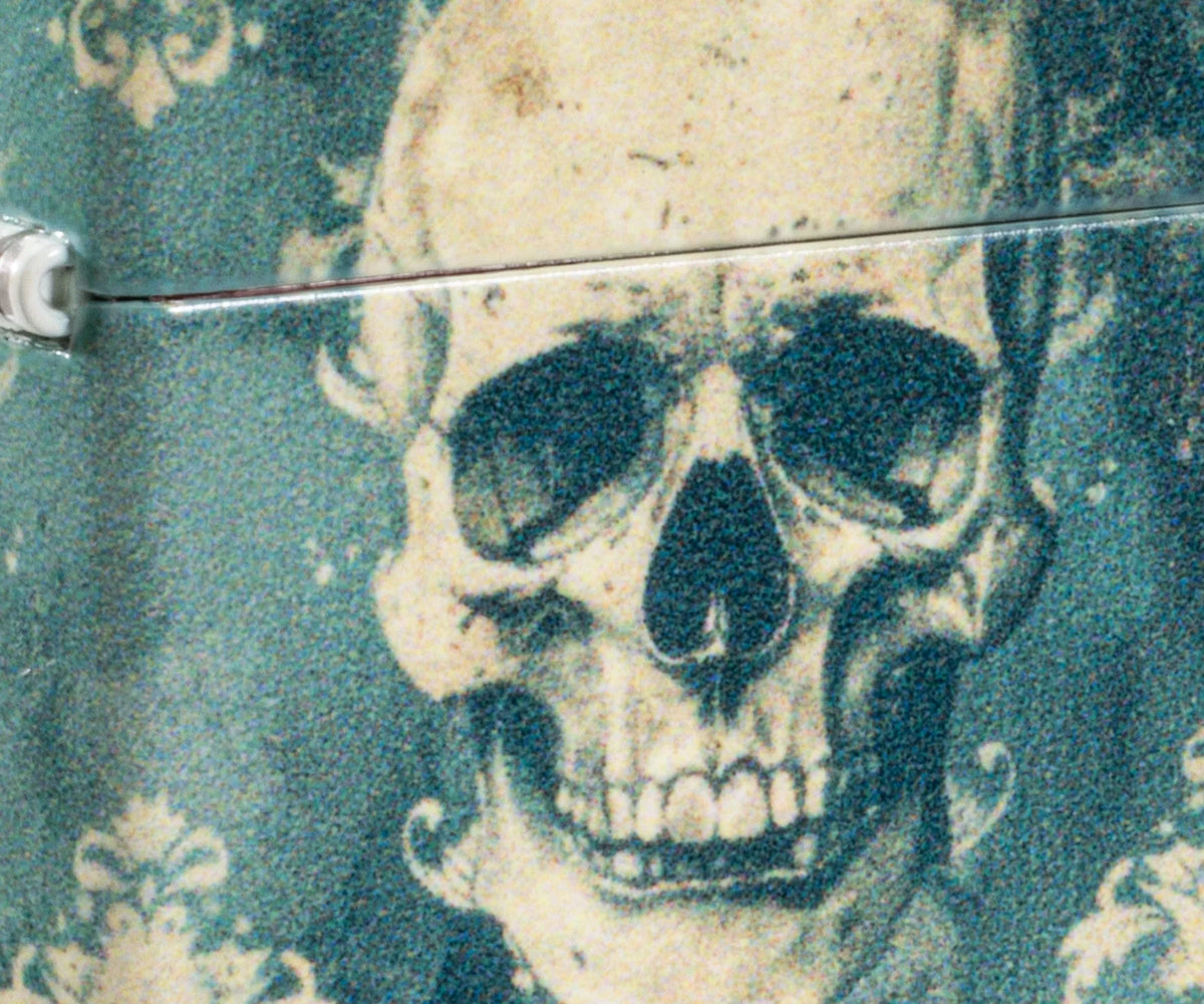 Detailaufnahme Zippo Totenkopf Motiv mit dunklen Konturen auf türkisgrünem Hintergrund