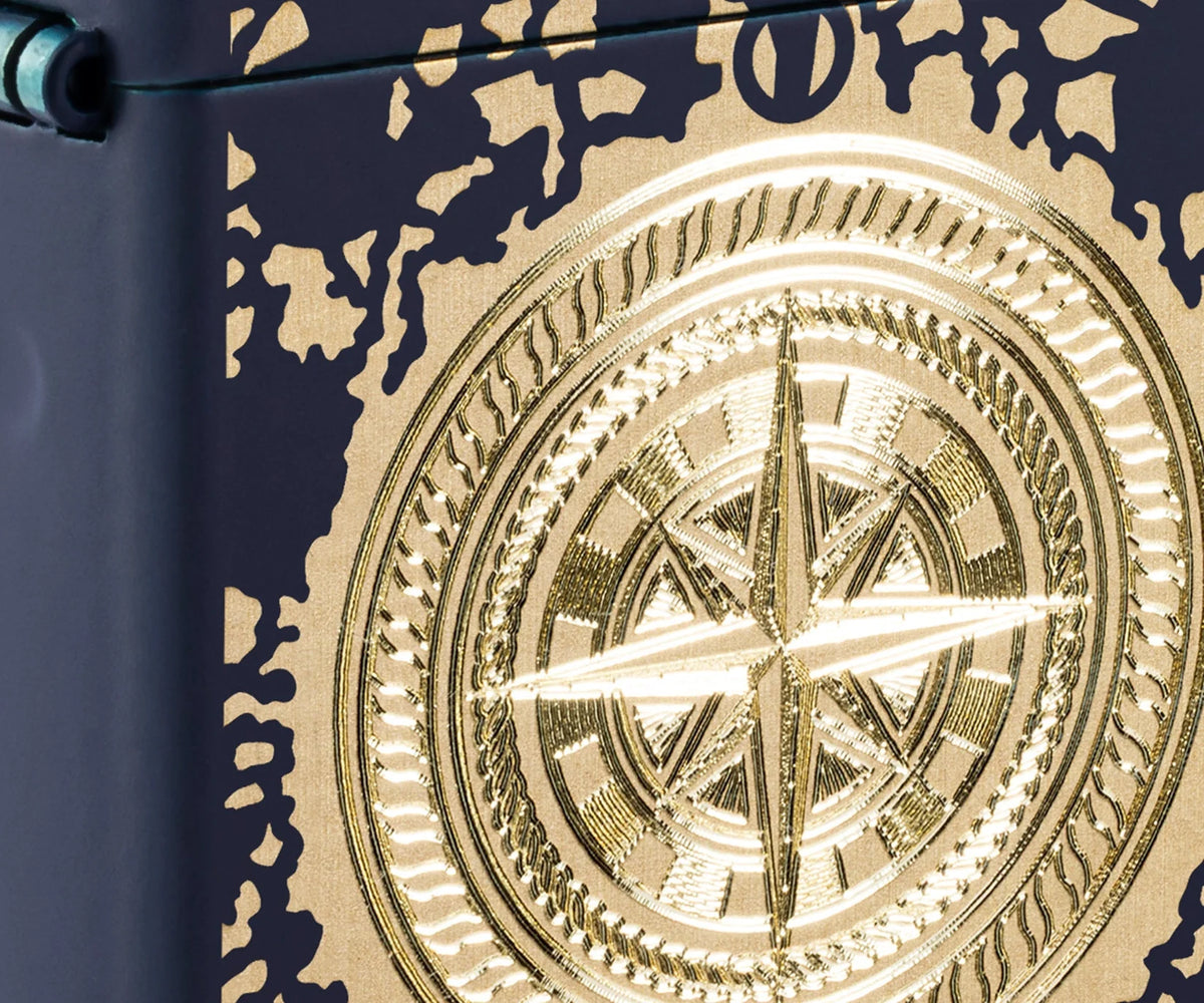 Detailaufnahme des goldfarbenen Kompassmotivs auf dunkler matter Zippo Oberfläche