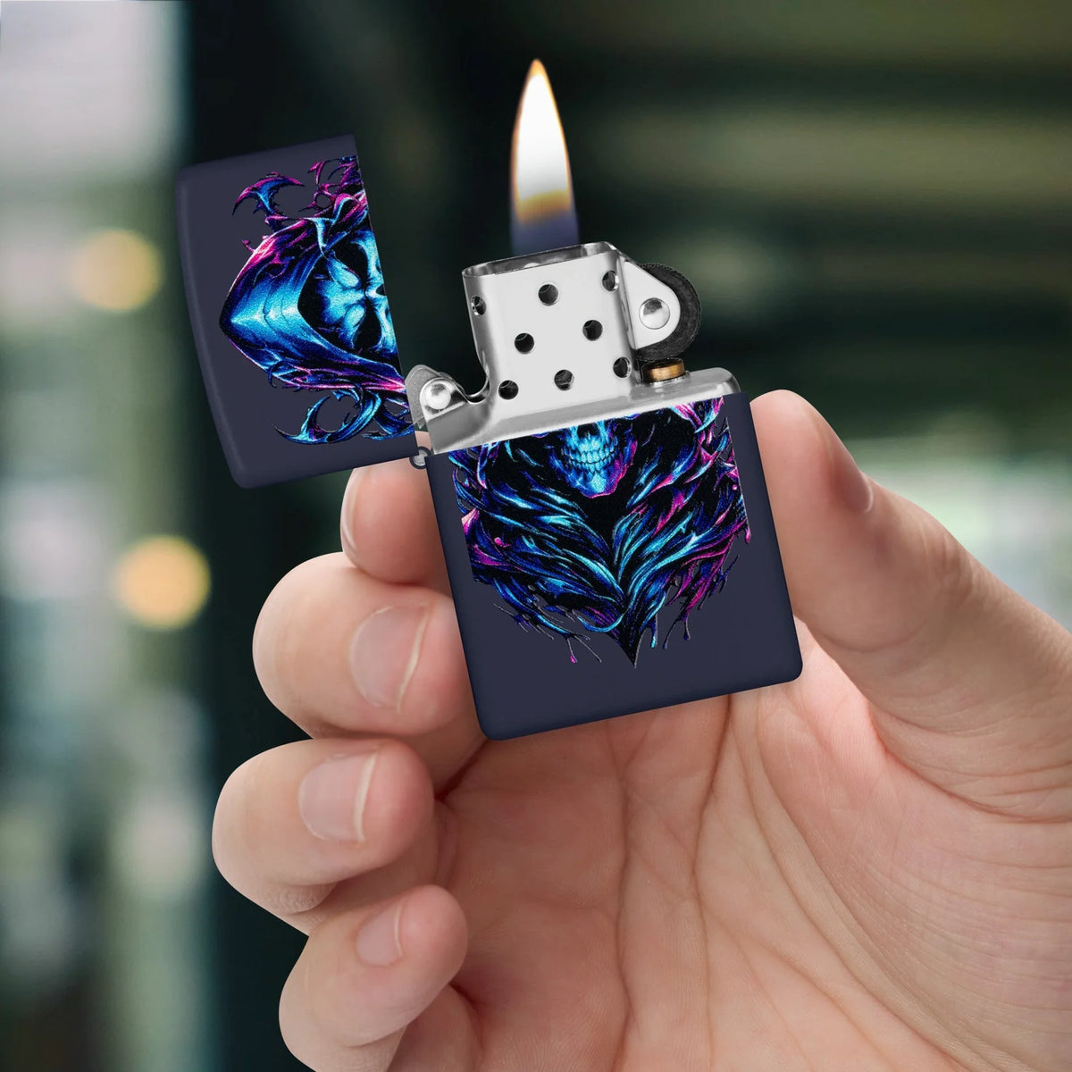 Geöffnetes Zippo Engel des Todes mit brennender Flamme, gehalten zwischen den Fingern vor unscharfem Hintergrund