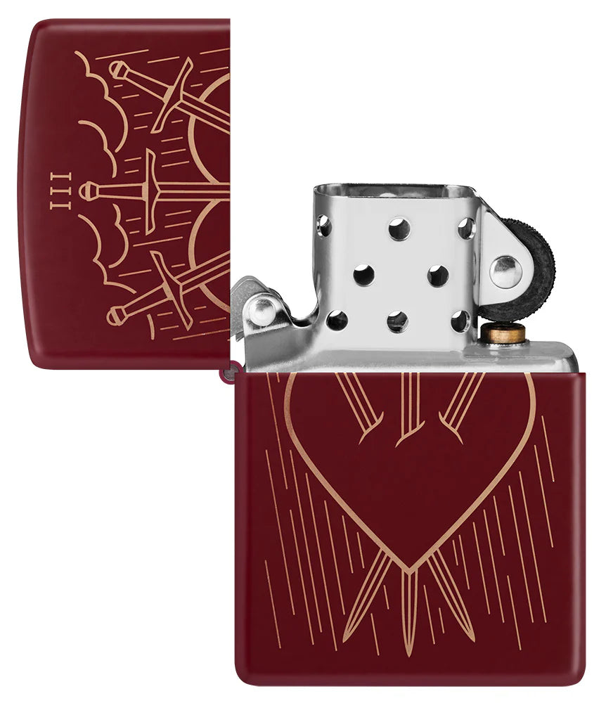 Geöffnetes Zippo-Feuerzeug in Merlot-Rot mit lasergraviertem Drei-der-Schwerter-Design, das ein durchbohrtes Herz mit regnerischem Hintergrund zeigt