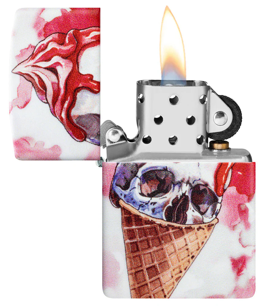 Das gleiche Zippo-Feuerzeug mit geöffnetem Deckel, das metallische Innere und die brennende Flamme zeigend, mit dem kompletten Totenkopf-Eiscreme-Design auf dem Gehäuse.